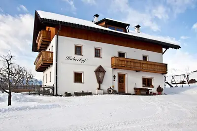 a house in the snow with snow covered ground at Huberhof Morgensonne in Terento