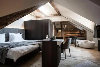 a bedroom with a large bed and a bath tub at Hotel Ansitz Steinbock in Villandro