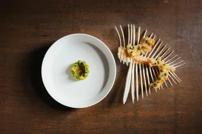 a white plate with a piece of food on top of a table at Hotel Ansitz Steinbock in Villandro