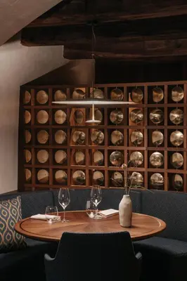 a table with two glasses and a wine cellar at Hotel Ansitz Steinbock in Villandro