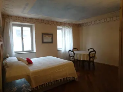 a bedroom with a bed and a table and a window at Ugo Art Lodge Classic in Bolzano
