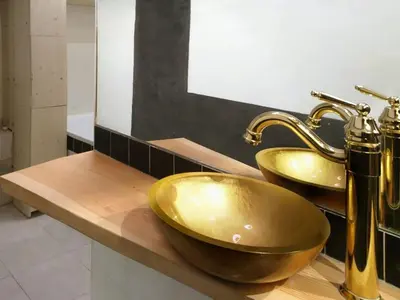 a bathroom with two gold sinks on a counter at Ugo Art Lodge Classic in Bolzano