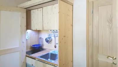 a small kitchen with wooden cabinets and a sink at Ugo Art Lodge Classic in Bolzano