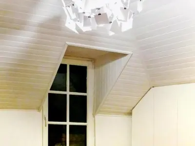a white ceiling with a window and a chandelier at Ugo Art Lodge Bright in Bolzano