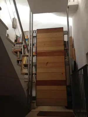 a hallway with a wooden door and a book shelf at Ugo Art Lodge Bright in Bolzano