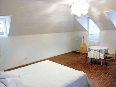 a bedroom with two beds and a table and chairs at Ugo Art Lodge Bright in Bolzano