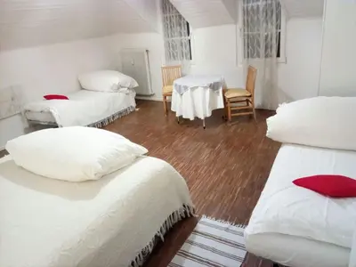 a room with three beds and a table and chairs at Ugo Art Lodge Bright in Bolzano