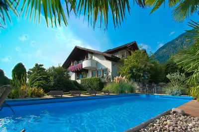 a villa with a swimming pool in front of a house at Guesthouse Christine in Marlengo