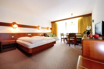 a hotel room with a bed and a living room at Residence Bacher in Valdaora