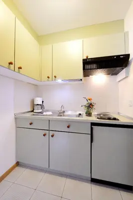 a kitchen with white cabinets and a sink at Residence Bacher in Valdaora