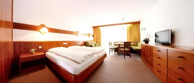 a hotel room with a bed and a television at Residence Bacher in Valdaora