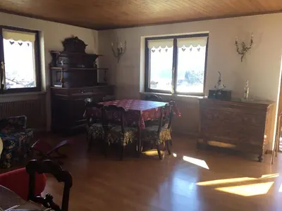 a dining room with a table and chairs and windows at Quater Apartments - Cavalese in Cavalese