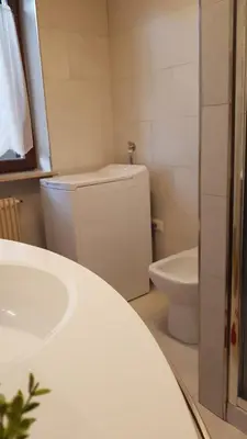 a white bathroom with a toilet and a sink at Quater Apartments - Cavalese in Cavalese