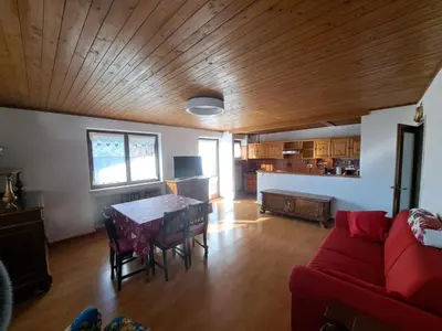 a living room with a table and a red couch at Quater Apartments - Cavalese in Cavalese