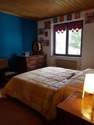 a bedroom with a large bed and a window at Quater Apartments - Cavalese in Cavalese