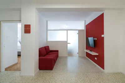 a living room with a red couch and a tv at Apartment Duomo in Bolzano