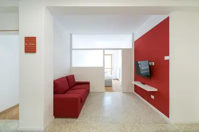 a living room with a red couch and a tv at Apartment Duomo in Bolzano