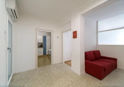 a living room with a red couch and a mirror at Apartment Duomo in Bolzano