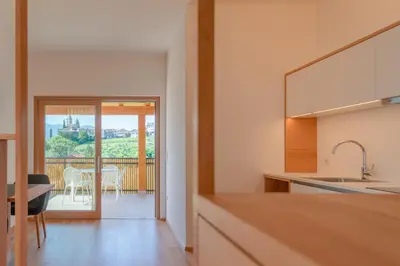 a kitchen with a view of a table and chairs at Sonnenhof Tramin - Adults Only in Termeno
