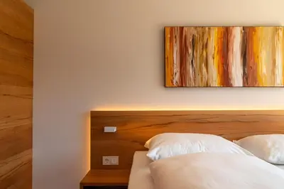 a bedroom with a bed and a painting on the wall at Sonnenhof Tramin - Adults Only in Termeno
