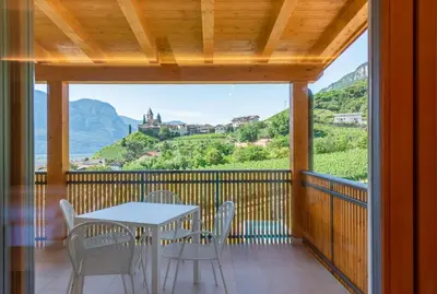 a table and chairs on a balcony with a view at Sonnenhof Tramin - Adults Only in Termeno