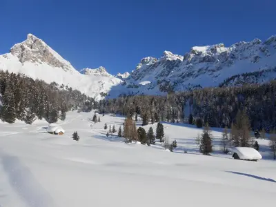 a living room with a couch and a kitchen at Tobià de Barat in Pozza di Fassa