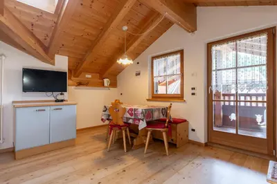 a kitchen and dining room with a table and chairs at Tobià de Barat in Pozza di Fassa