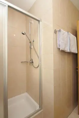 a shower with a glass door in a bathroom at Paderlafoderhof in Laion