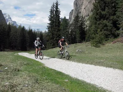 two people riding bikes down a gravel road at Paderlafoderhof in Laion