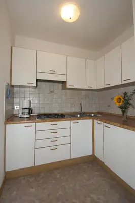 a kitchen with white cabinets and a sink at Paderlafoderhof in Laion