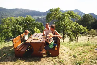 a group of people sitting at a picnic table at Paderlafoderhof in Laion