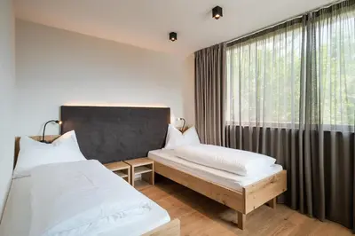 a bedroom with two beds and a window at Aparthotel Abiná Lana Höhe in Lana