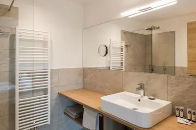 a bathroom with a sink and a mirror at Aparthotel Abiná Lana Höhe in Lana