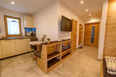 a kitchen and dining room with a table and a television at Chalet Schwarzenstein in Campo Tures