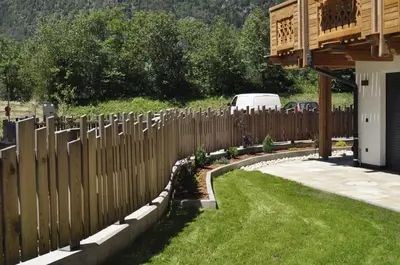 a wooden fence in front of a yard at Chalet Schwarzenstein in Campo Tures