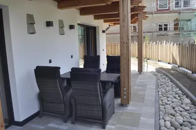 a wooden table and chairs on a patio at Chalet Schwarzenstein in Campo Tures