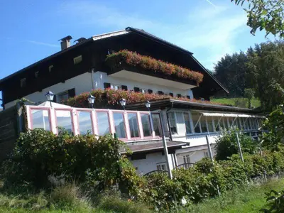 a house with a balcony with flowers on it at Panoramahotel Unterinnerhof in Auna di Sotto