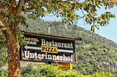a sign for a hotel near a mountain at Panoramahotel Unterinnerhof in Auna di Sotto