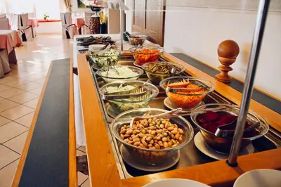 a kitchen counter with many bowls of food on it at Panoramahotel Unterinnerhof in Auna di Sotto