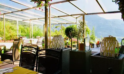 a restaurant with tables and chairs and a glass roof at Panoramahotel Unterinnerhof in Auna di Sotto