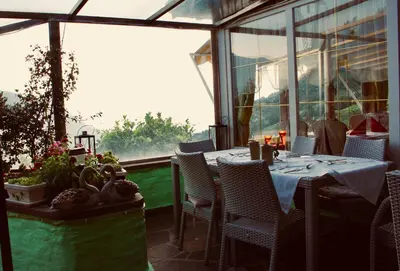 a dining room with a table and chairs and a window at Panoramahotel Unterinnerhof in Auna di Sotto