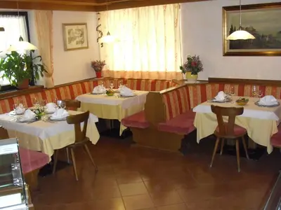 a dining room with two tables and chairs in a restaurant at Panoramahotel Unterinnerhof in Auna di Sotto