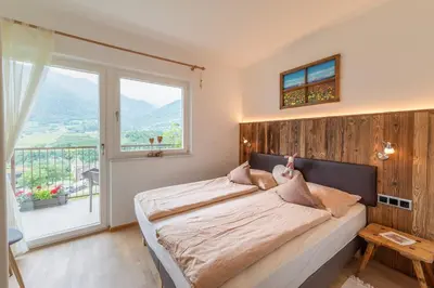 a bedroom with a large bed and a large window at Haus Karin view in Brixen