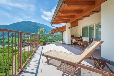 a patio with a table and chairs on a balcony at Haus Karin view in Brixen