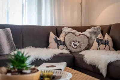 a brown couch with pillows on it with a table at Haus Karin view in Brixen