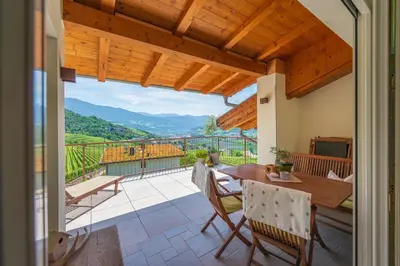 a patio with a wooden table and chairs on a balcony at Haus Karin view in Brixen
