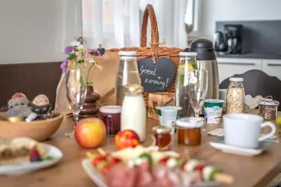 a table topped with plates of food and a basket of food at Haus Karin view in Brixen