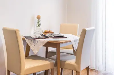 a dining room table with four chairs and a table with a table cloth at Sonnleitn in Laion