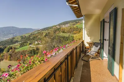 a balcony with a view of flowers and mountains at Sonnleitn in Laion