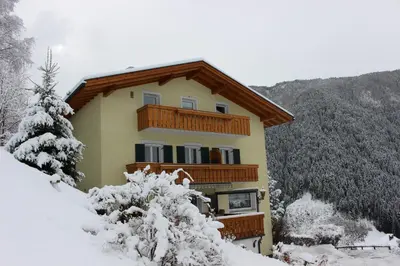 a building with a balcony in the snow at Sonnleitn in Laion